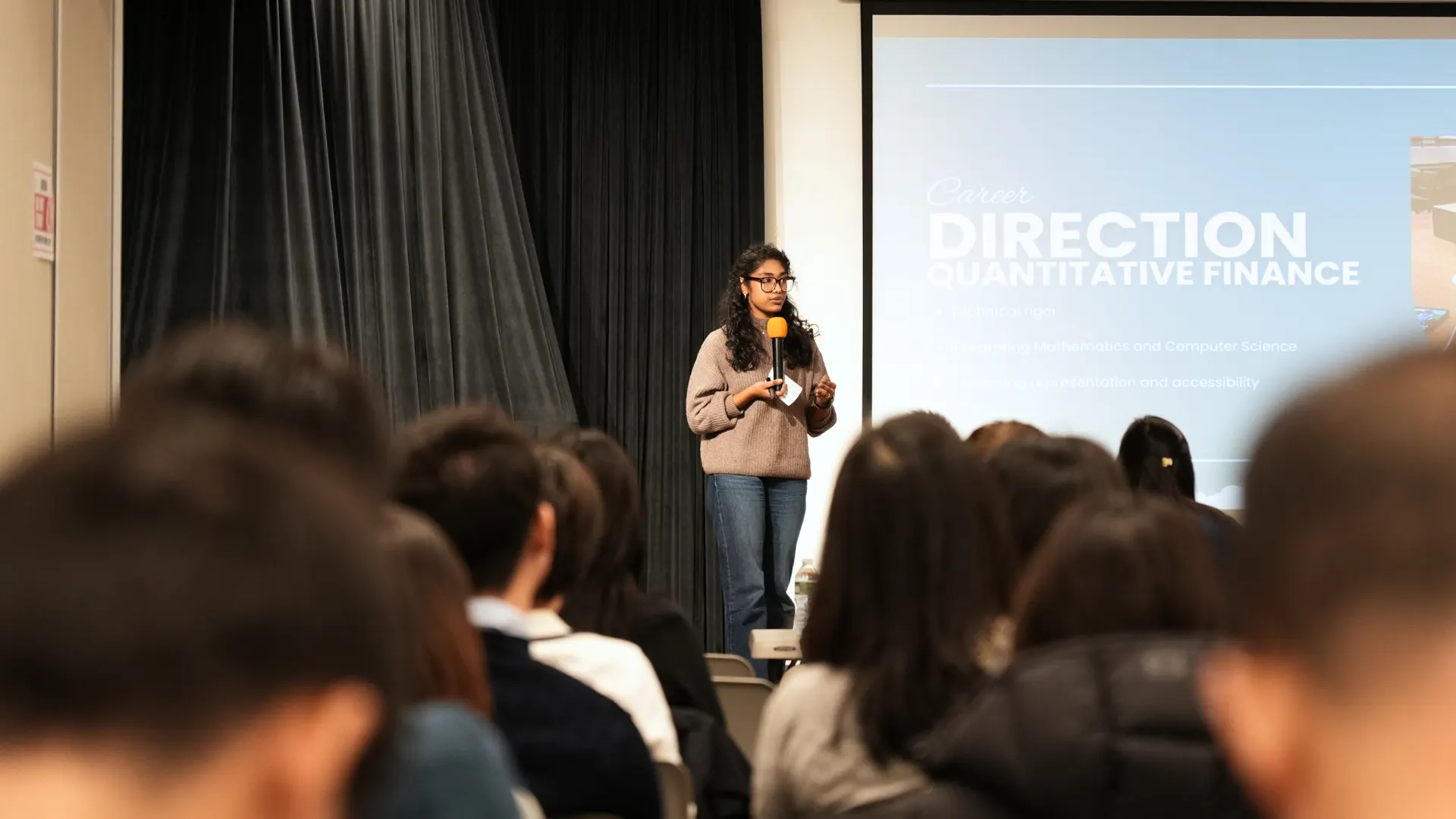 A CAAF program participant presenting on quantitative finance career pathways to a full room of students.