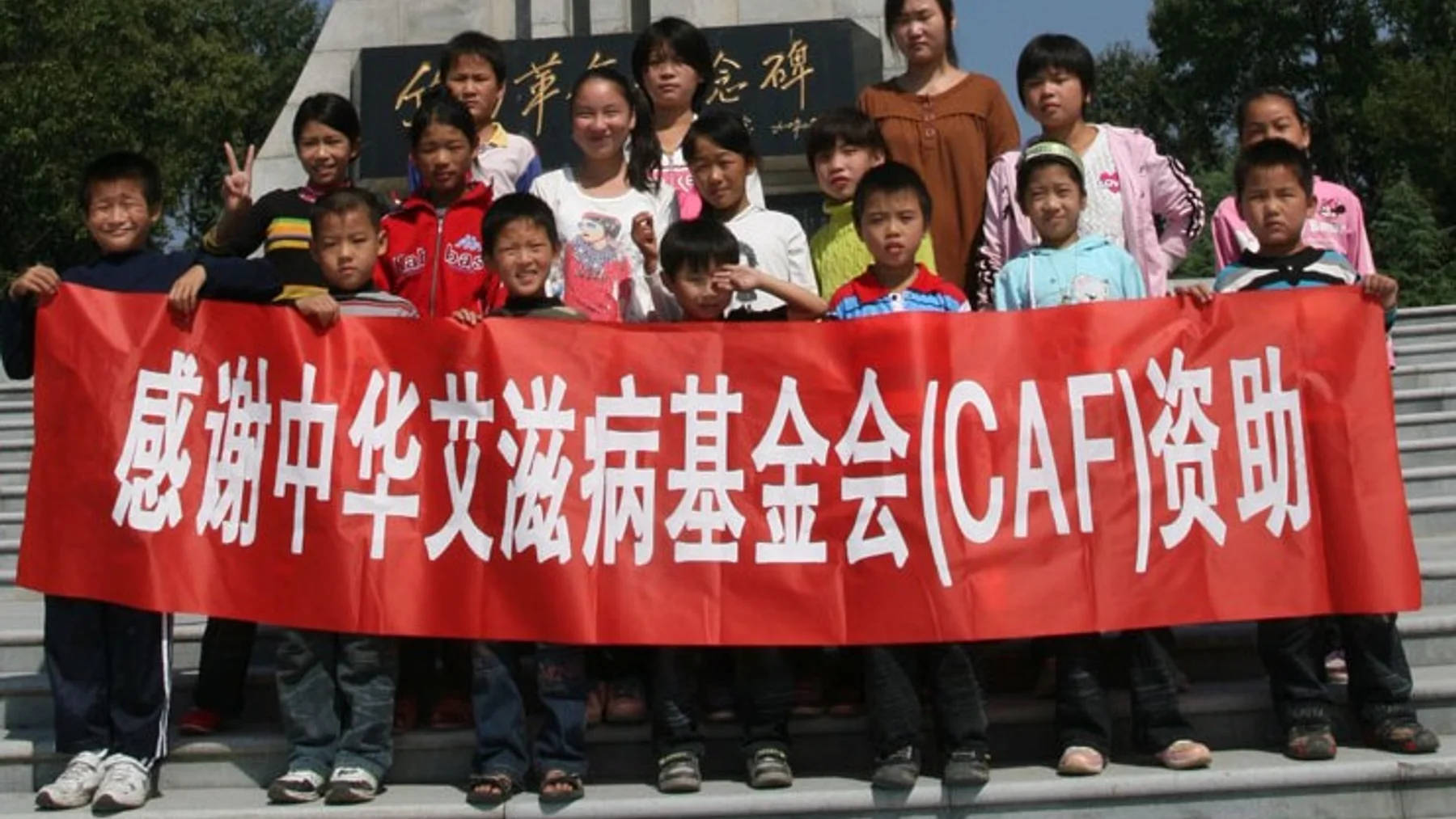 Children in Henan holding a banner thanking China AIDs Fund for its support.