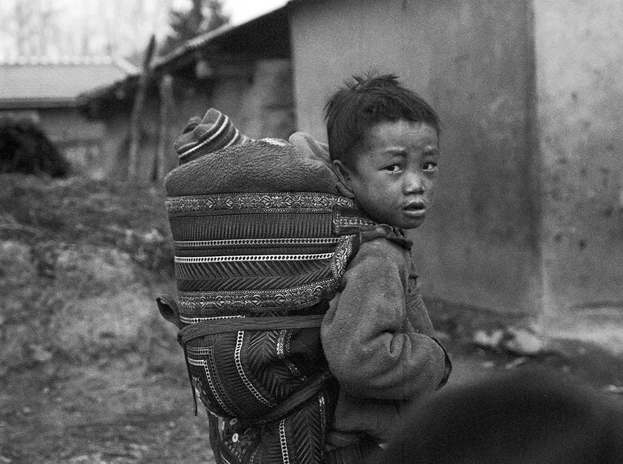 A child carrying a younger sibling, Liangshan Prefecture.