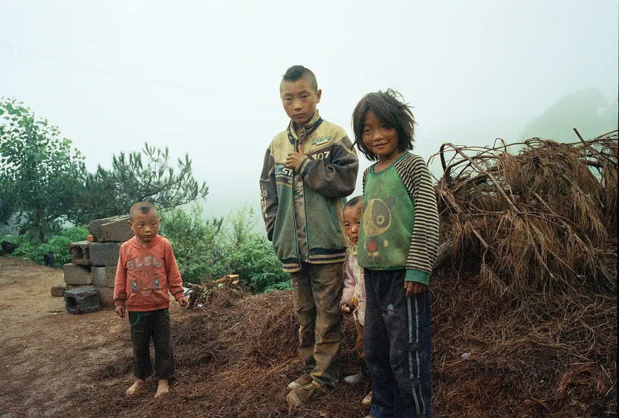 Children beside a haystack, Liangshan Prefecture.