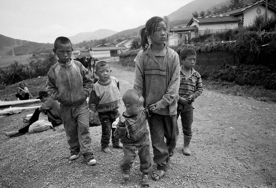 Children walking together through the village, Liangshan Prefecture.