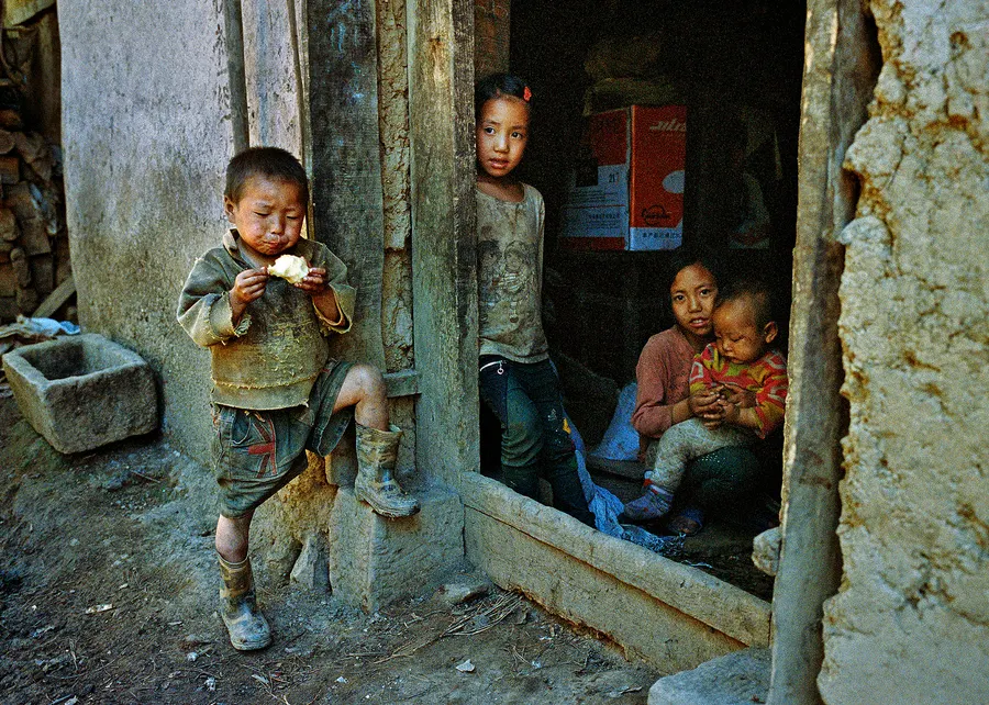 Children in the doorway of a home, Liangshan Prefecture.