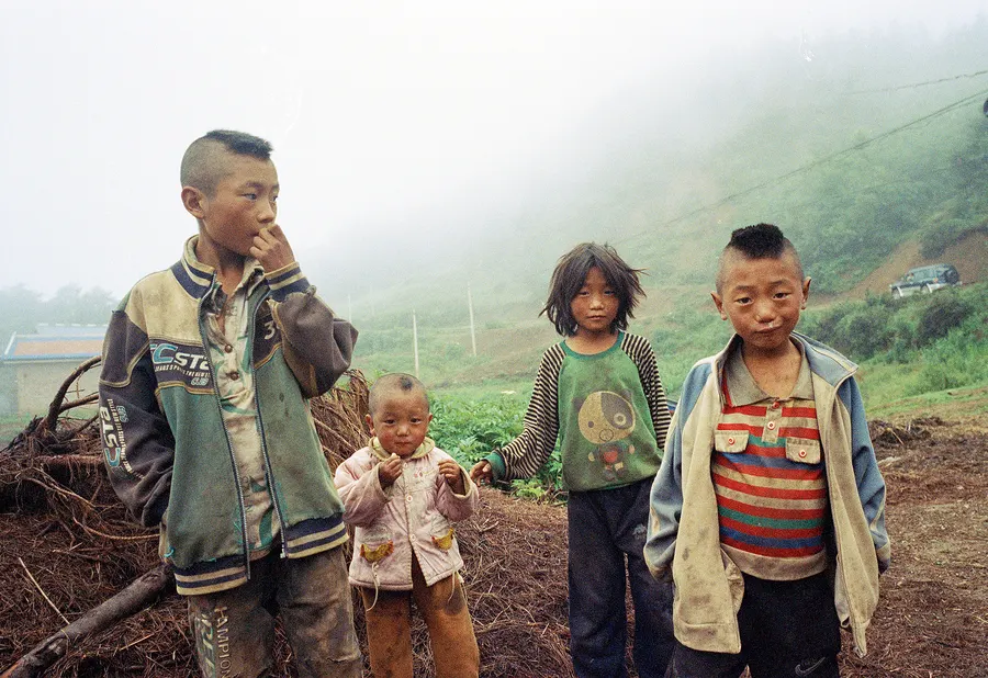 Four children on a misty hillside, Liangshan Prefecture.
