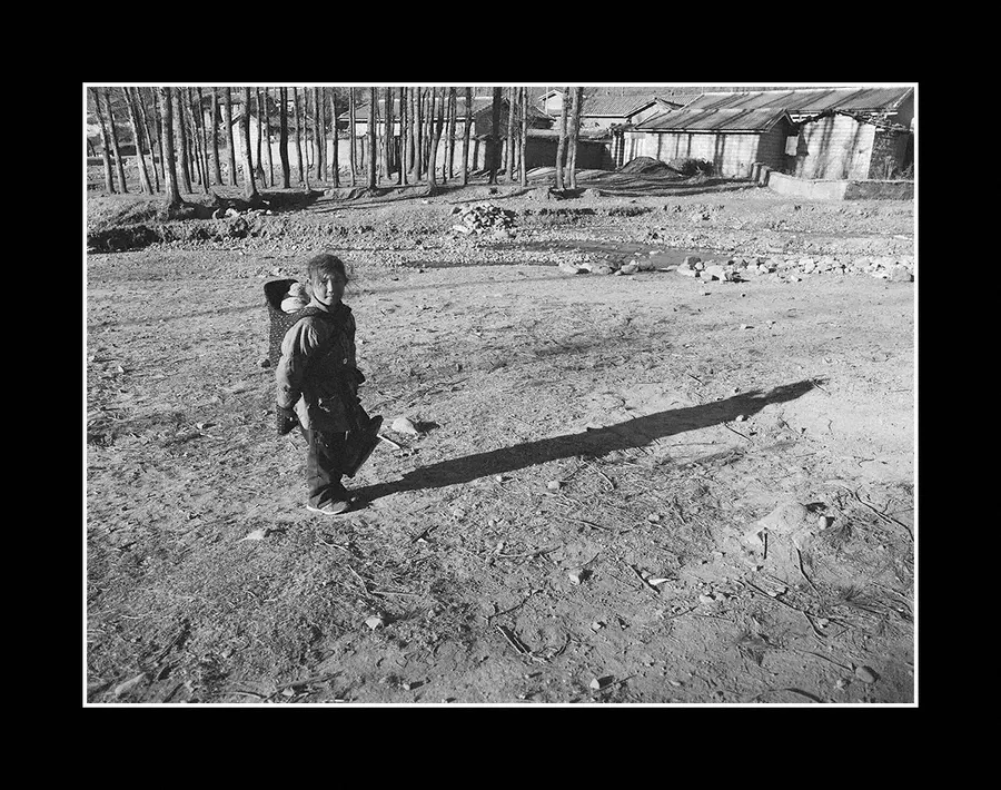 A child crossing open ground alone, Liangshan Prefecture.