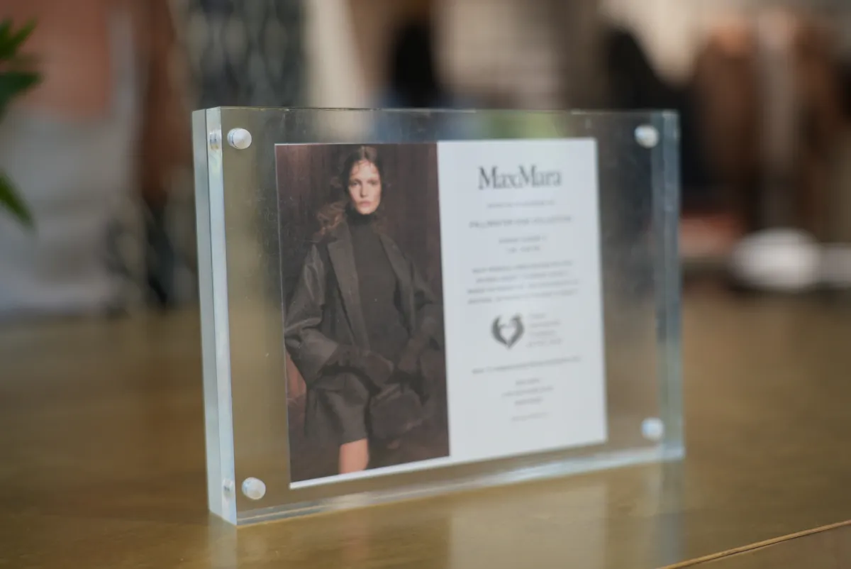The Max Mara and CAAF event card displayed in the store.